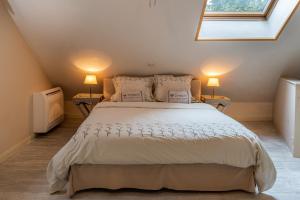 a bedroom with a large white bed with two lamps at Stadshuisje 36 in Hasselt