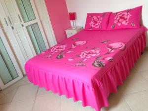 een roze bed met roze lakens en bloemen erop bij Guarujá/Acapulco Cond alto padrão in Guarujá