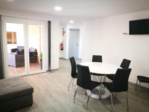 een woonkamer met een tafel en stoelen en een bank bij Casa do Forno do Ti Correia in Macedo de Cavaleiros