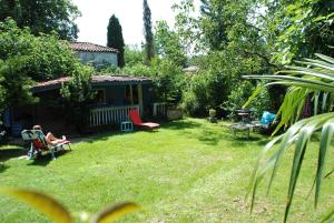 a woman sitting in a chair in a yard at les 2 studios indépendants du clos de l'Ange in Rieux