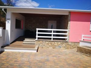 een huis met een roze en wit gebouw bij Casa do Forno do Ti Correia in Macedo de Cavaleiros