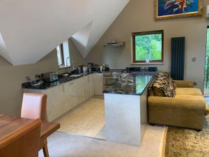 a kitchen with a counter and a couch in a room at Luxurious private coach house in Nailsea