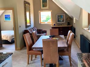 a dining room with a table and chairs and a couch at Luxurious private coach house in Nailsea