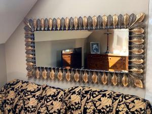 a mirror on a wall with a bed in a room at Luxurious private coach house in Nailsea