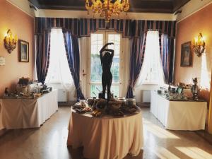 a room with a statue of a woman on a table at Duchessa Isabella Hotel & SPA in Ferrara
