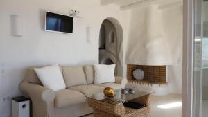 a living room with a couch and a fireplace at Villa Achilleas Crete in Ierápetra