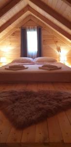 een groot bed in een houten kamer met een raam bij Little Paradise in Virpazar