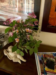 un jarrón lleno de flores sentado en una mesa en La Maison d'Alice, en Vézac