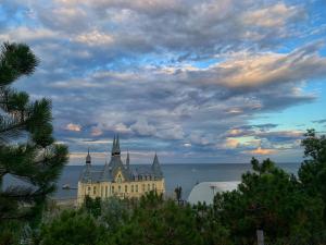 a large building with towers on the water under a cloudy sky at Room1402 in Odesa