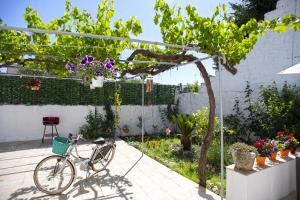 Una bicicleta estacionada en un jardín con flores en Il Segnalibro B&B, en Alberobello