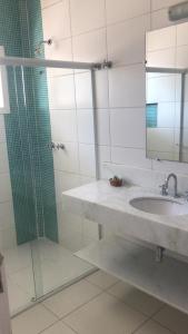 a bathroom with a sink and a glass shower at Pousada Cana Caiana in Paraty