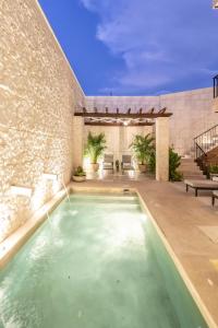 a swimming pool in the middle of a house at Casa Tavera- Adults Only in Mérida