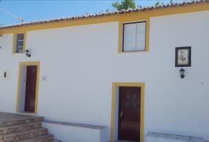 Casa blanca con puerta y escalera en Casa São João en São Salvador da Aramenha