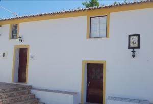 a white house with a door and a staircase at Casa São João in São Salvador da Aramenha