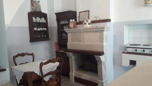 a kitchen with a fireplace and a table and chairs at Le dimore del Mercante in Luco neʼ Marsi