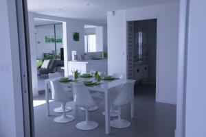 une salle à manger blanche avec une table blanche et des chaises blanches dans l'établissement Design Apartment - Pool, Large Terrace and Panoramic Views of Mediterranean, à Bandol