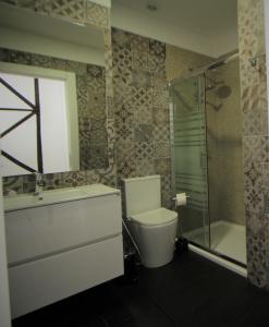 y baño con aseo y ducha acristalada. en Frutaria - Lisbon Suites en Lisboa
