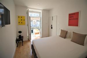 Un dormitorio con una gran cama blanca y una ventana en Frutaria - Lisbon Suites en Lisboa