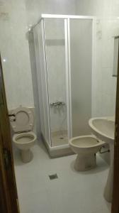 een badkamer met een douche, een toilet en een wastafel bij casa cachafeiro in Rodeiro