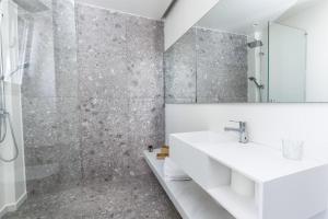 a bathroom with a sink and a shower at Paralos Lodging in Schinoussa