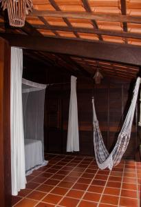 Habitación con 2 hamacas colgadas del techo en Jangada Lodge, en São Miguel do Gostoso