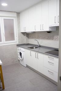 - une cuisine blanche avec un évier et un lave-vaisselle dans l'établissement IZASKUNena Home E-BI 1190, à Getxo