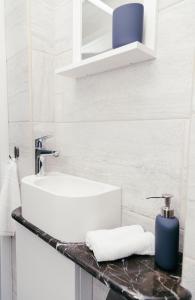 biała łazienka z umywalką i blatem w obiekcie IZU Home w Rydze