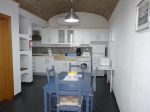 eine Küche mit einem blauen Tisch und Stühlen in der Unterkunft Páteo dos Oliveira - Casa dos Serviçais in Évora