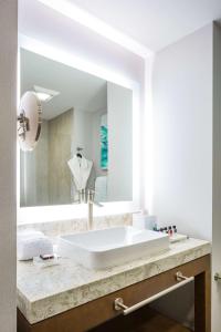 ein Badezimmer mit einem weißen Waschbecken und einem Spiegel in der Unterkunft Best Western Premier Hotel at Fisher's Landing in Vancouver
