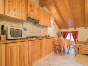 cocina con armarios de madera y microondas en Agritur Al Paradis - Appartamenti, en Portolo