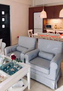 ein Wohnzimmer mit 2 Stühlen und einem Tisch in der Unterkunft Seaside Family House in Nikiana
