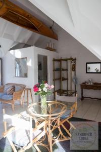 a living room with a glass table and chairs at Sandriver Lodge in St Francis Bay