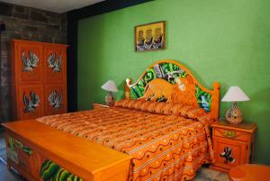 a bedroom with an orange bed and green walls at Hotel Boutique Posada la Casona de Cortés in Tlaxcala de Xicohténcatl