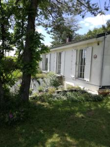 a white house with a tree in front of it at Les Tiennes in Treignes