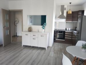 a kitchen with white cabinets and a white counter top at Narutowicza Modern Apartment 2 in Słupsk