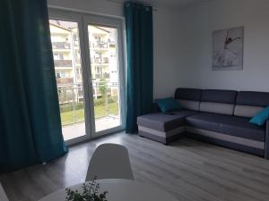 スウプスクにあるNarutowicza Modern Apartment 2のソファと大きな窓のあるリビングルーム