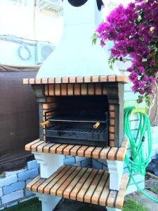 a brick fireplace sitting on a bench with flowers at Casa Rural Las Gamellas in Rebollar