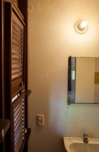 La salle de bains est pourvue d'un lavabo et d'un miroir mural. dans l'établissement Jangada Lodge, à São Miguel do Gostoso