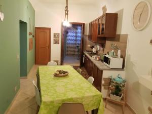 a kitchen with a table with a green table cloth on it at Ai Carrettieri della Cattedrale in Palermo