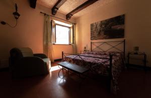 a bedroom with a bed and a chair and a window at Villa il Parco in Bracciano