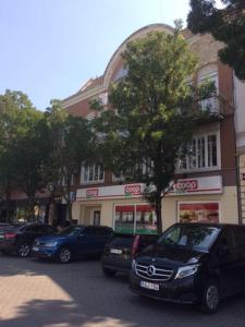 a group of cars parked in front of a building at Baross-hat apartmanház in Szolnok