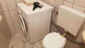 a bathroom with a toilet with a gun on top of it at Apartment 22 Omiš in Omiš +62 photos