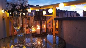 een tafel met wijnglazen en bloemen op een balkon bij Silver Apartaments in Piła