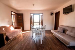 a living room with a table and a couch at Morada Canto Norte - Apartamentos Beira Mar in Garopaba