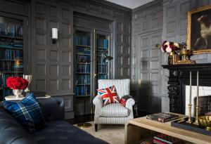 a living room with a couch and a chair and a fireplace at The George in Montclair