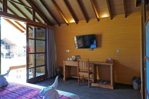 - une chambre avec un bureau et une télévision murale dans l'établissement Wah Resort Gili Trawangan, à Gili Trawangan
