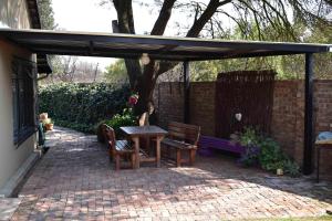 a patio with a table and chairs under a pavilion at 13 Hobson in Secunda
