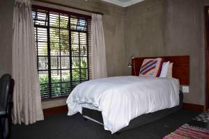 a bedroom with a bed and a large window at 13 Hobson in Secunda
