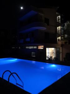 a blue swimming pool in front of a building at night at Villa Santa Barbara in Cefalù