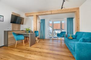 sala de estar con sofá azul y mesa en Herzstück Waldkirchen 4 Sterne Hotel, en Waldkirchen